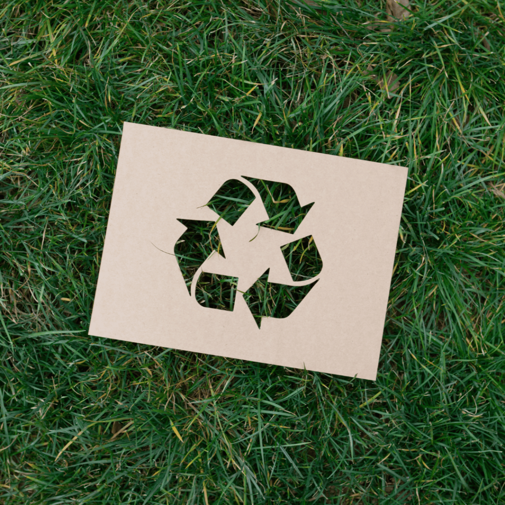 Знак за рециклиране, поставен върху трева